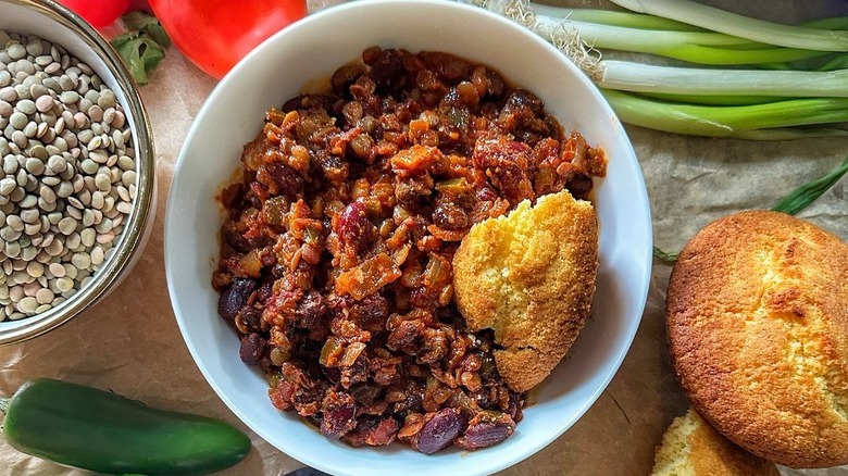 vegan chili and cornbread surrounded by fresh ingredients