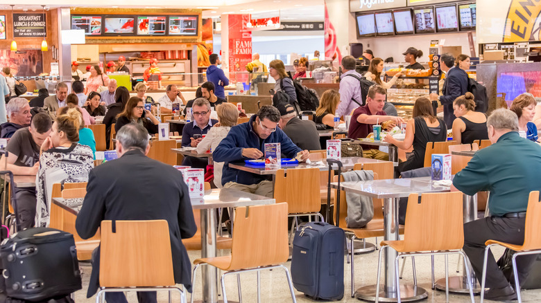 Many diners in a busy airport food court