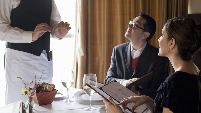 couple giving waiter menu orders