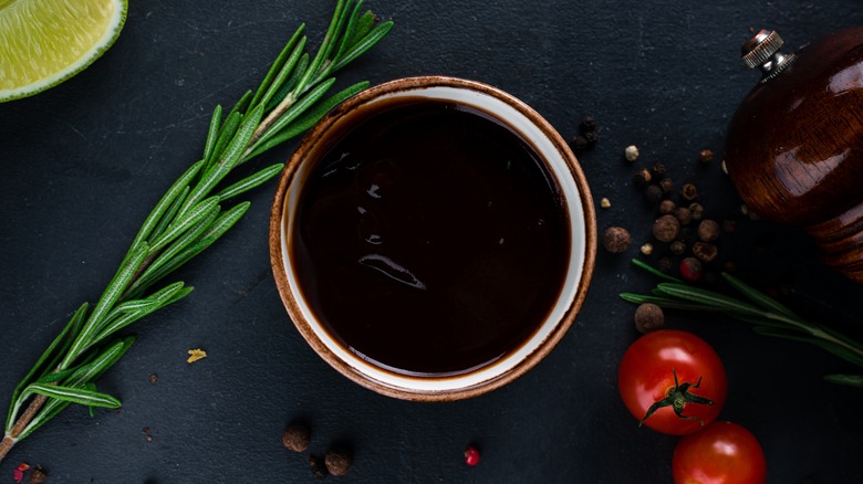 soy sauce in a bowl with herbs, spices, and tomatoes
