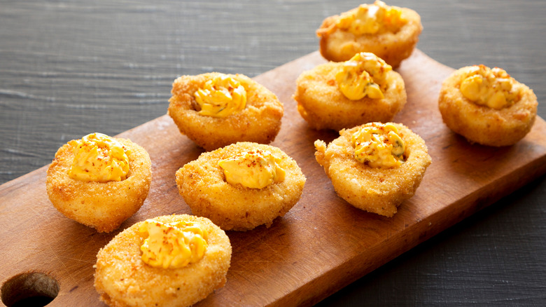 Fried deviled eggs on wooden cutting board