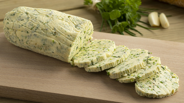 slices of homemade herb butter on cutting board