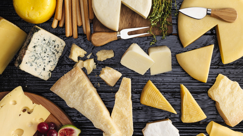 variety of cheeses on a wooden table