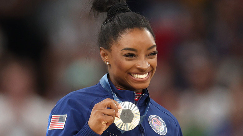 Simone Biles smiling with gold medal