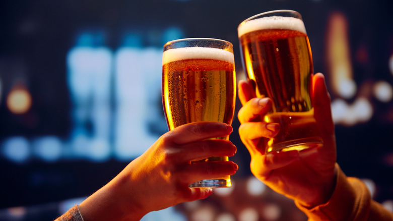 Two people clinking beer glasses