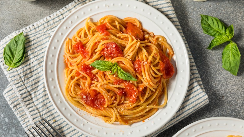 Plate of spaghetti with tomato sauce and basil