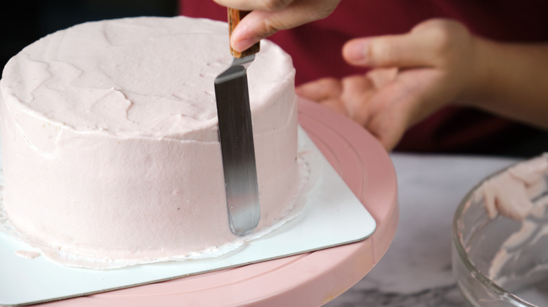 frosting a cake with whipped cream
