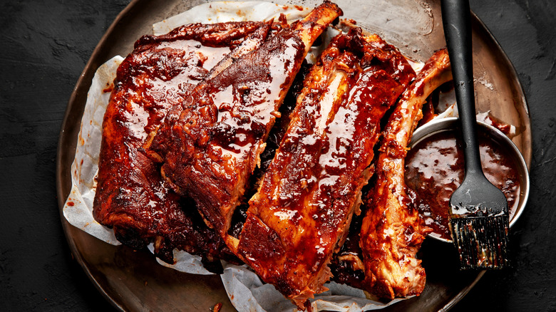 Sauced ribs next to barbecue sauce