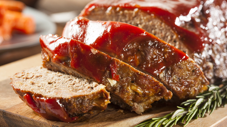 a cut meatloaf on a wooden cutting board