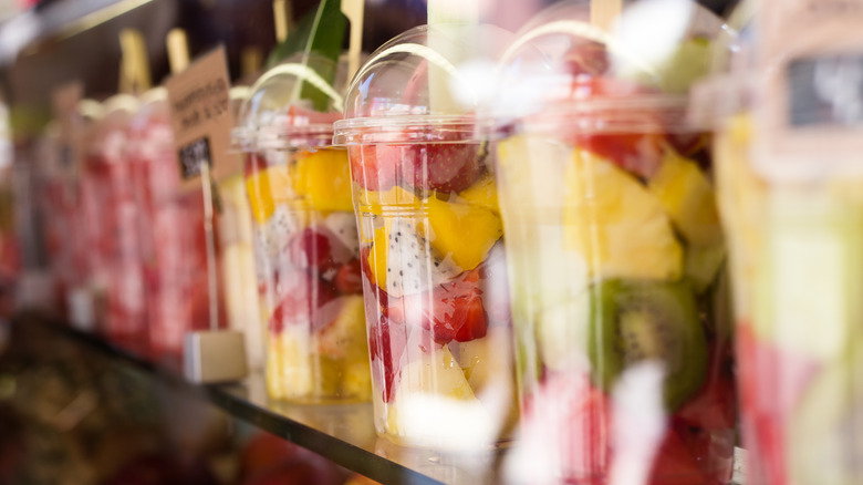 A row of pre-cut fruit cups in a supermarket