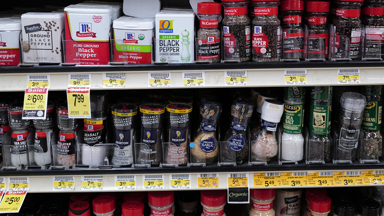 Jars of spices on the shelves at a grocery store.