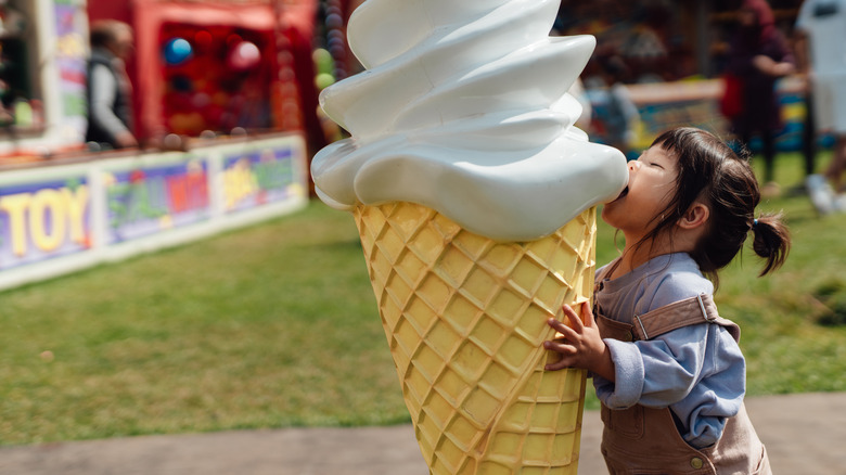 small child eating big ice cream cone 