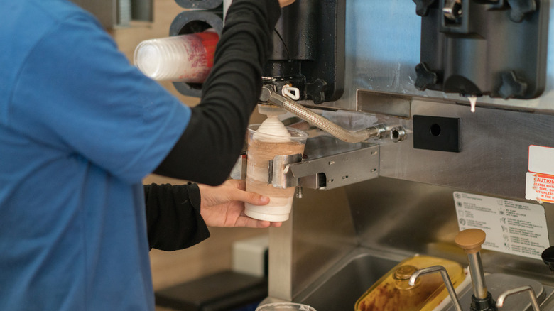 fast food employee making a milkshake 