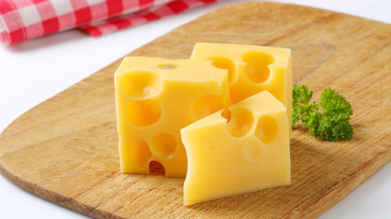 Pieces of Emmental cheese on cutting board