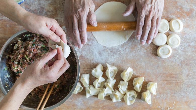 Overhead shot of two people filling dumplings