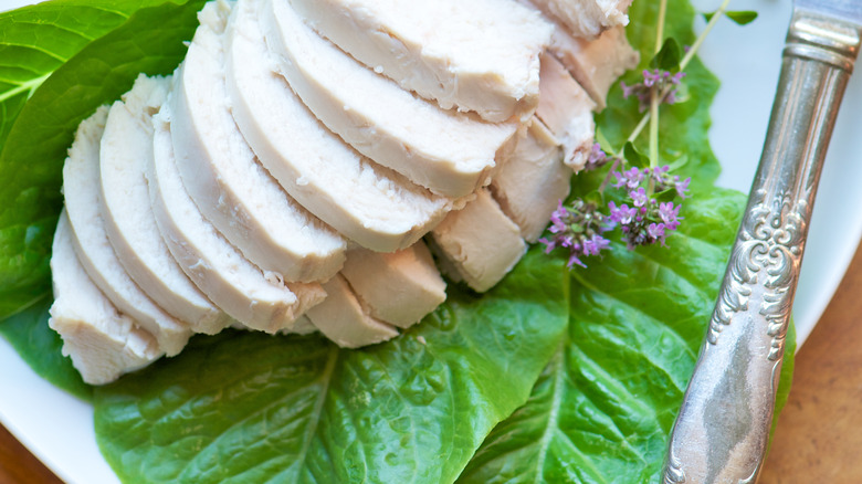 Poached, sliced chicken breast on lettuce leaf