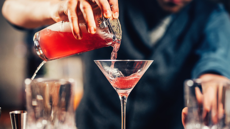 bartender pouring cosmopolitan cocktail