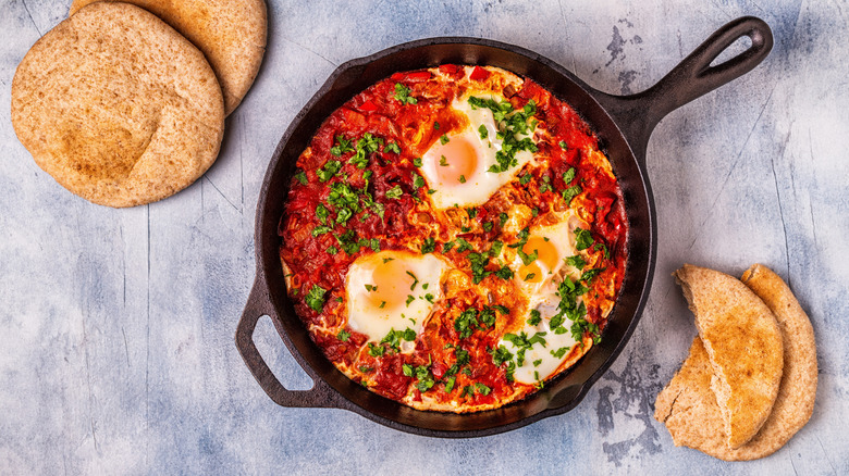 A cast iron pan is full of shakshuka.