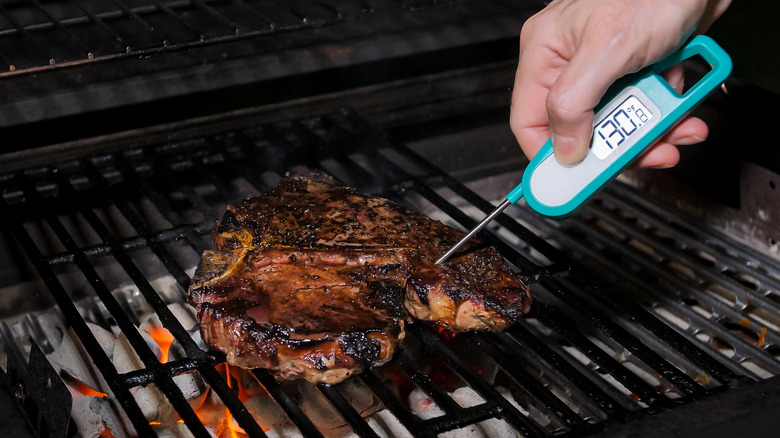 food thermometer checking the temperature of a steak