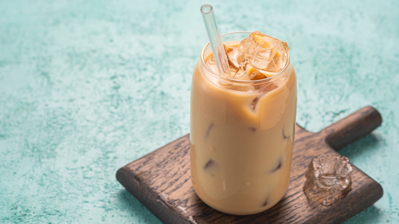 A glass of iced yuenyueng has a glass straw