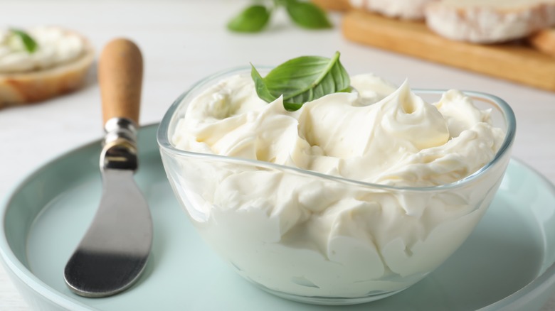 Cream cheese in glass bowl with basil