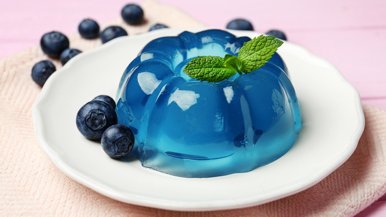 Blue Jell-o with berries on white plate