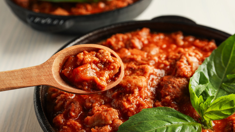 Wooden spool full of cooked meat from a Bolognese sauce