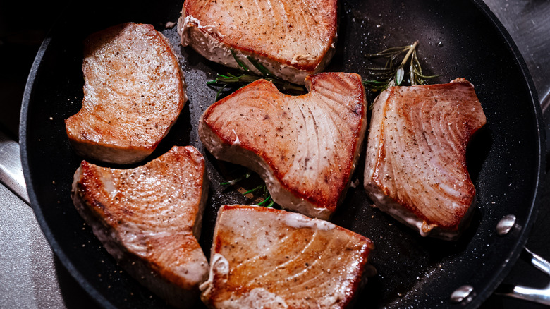 Tuna steaks getting seared in a pan