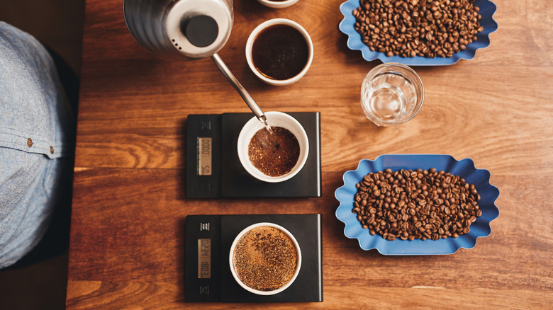 Person pouring water in coffee on a weighing scale