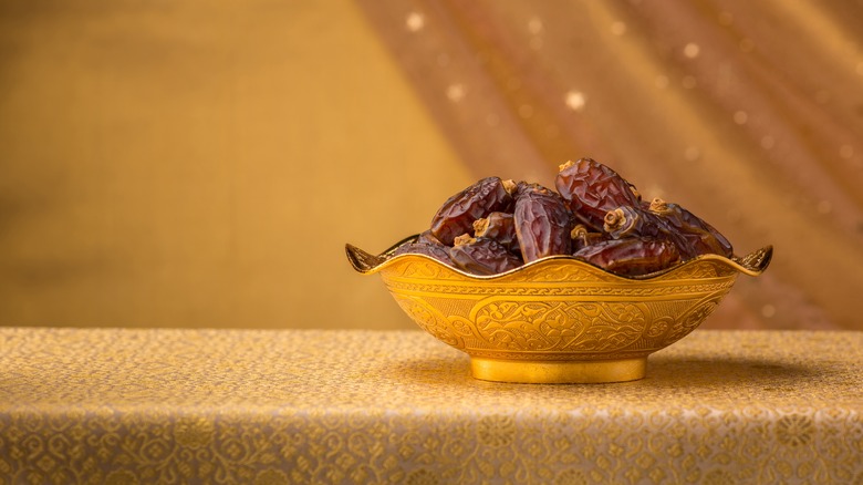 bowl of dried dates in golden background