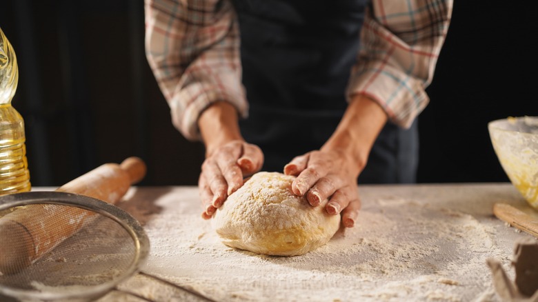 Person kneading pizza dough