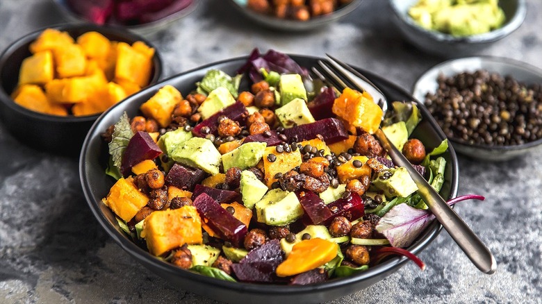 Plate of cooked sweet potatoes, lentils, beets, and avocado