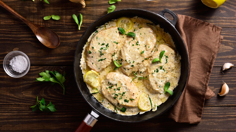 Chicken breast with cream sauce and herbs in pan