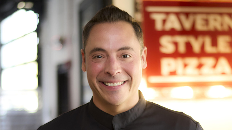 Jeff Mauro smiling in a chef coat