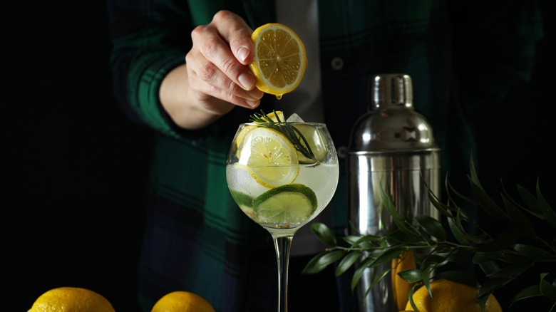 bartender squeezing lemon into cocktail