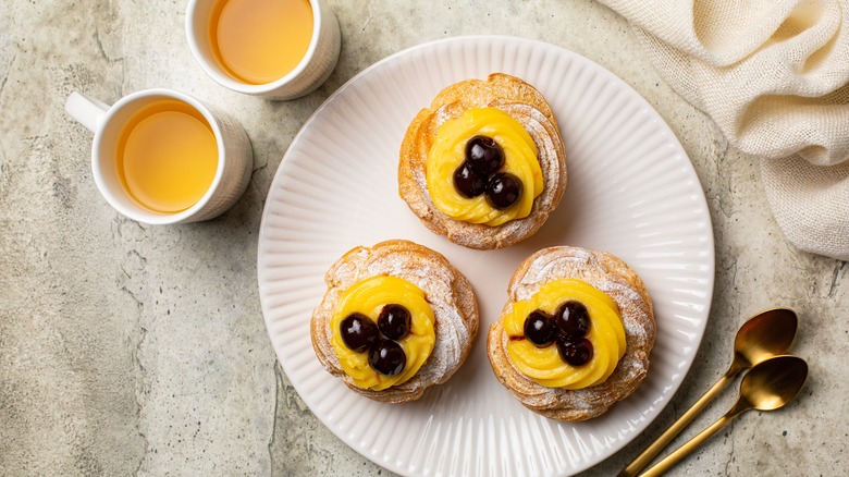 zeppole di san giuseppe with yellow icing and cherries with tea