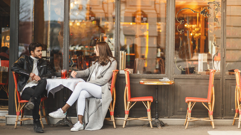 Two people sitting at sidewalk cafe