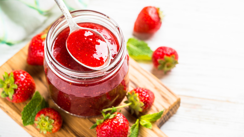 A spoon and a jar of strawberry jam