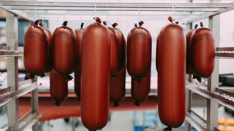 Bologna hanging in its casing before being sliced