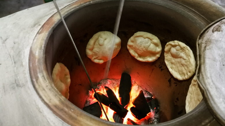 Naans inside a tandoor