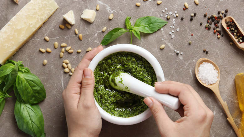 person making pesto with mortar and pestle