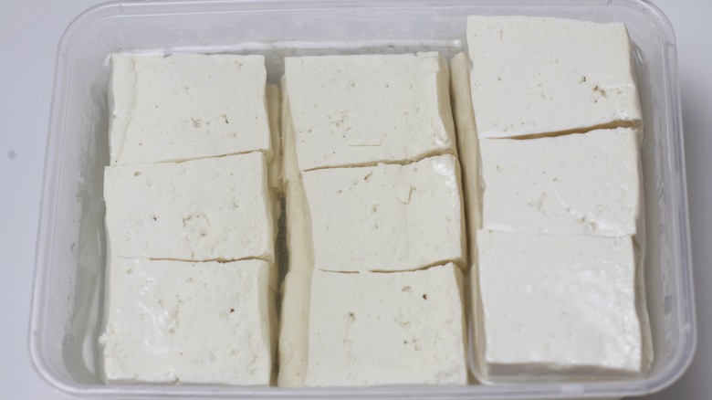 tofu in water in tupperware container