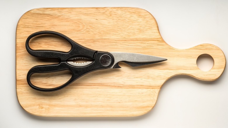 Kitchen shears on wooden cutting board