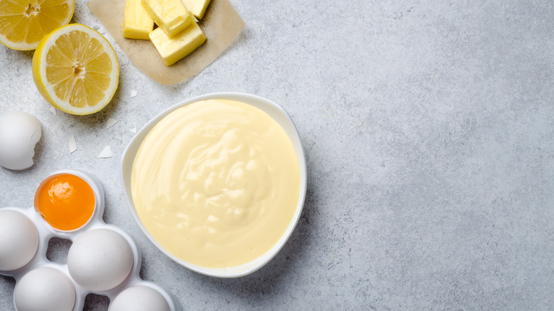 Bowl of hollandaise sauce next to ingredients