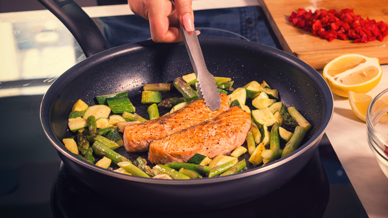 Salmon and vegetables being cooked in home kitchen