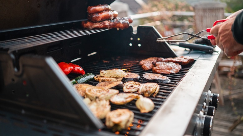 A grill loaded with various meats and veggies