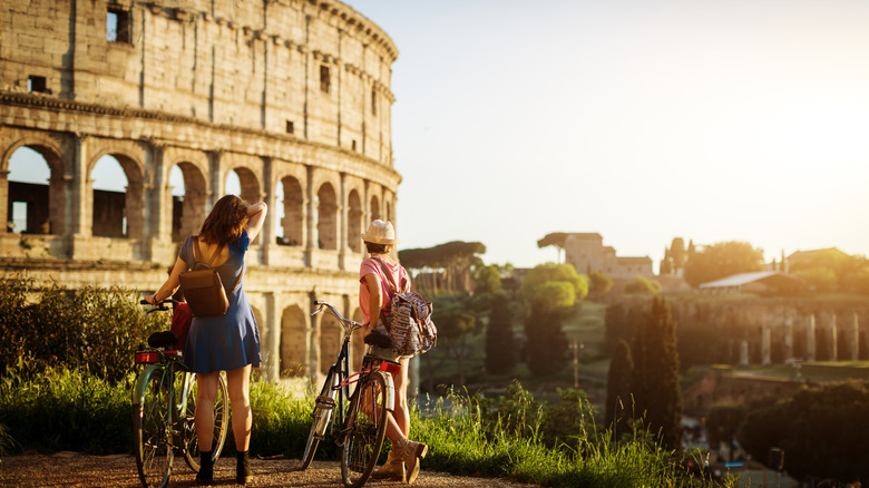 Two people with bikes near Colosseum 