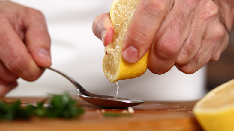 squeezing lemon juice onto spoon