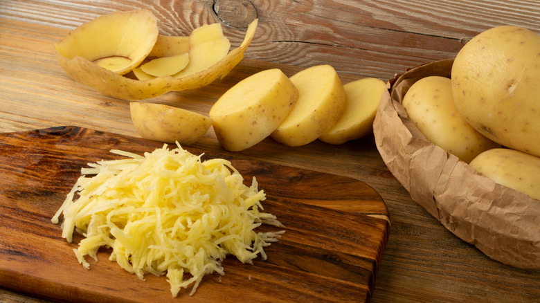Shredded potatoes on a wooden cutting board