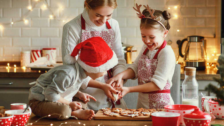 Mom decorating gingerbread cookies with kids